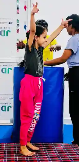 Girl holding a balance pose on the gymnastics floor at Kids Activity Centre, Rajeev Nagar, Patna