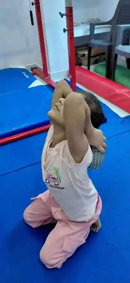 Young girl stretching her legs on the mat during gymnastics training in Patna