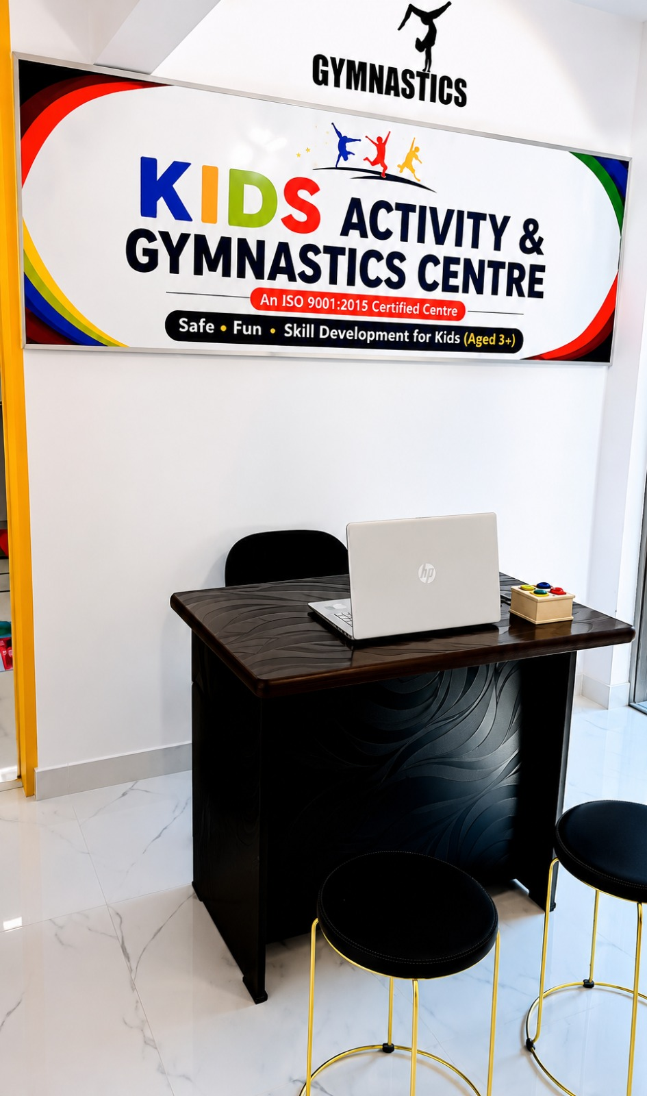 The centre reception desk with a laptop and Kids Activity & Gymnastics Centre sign