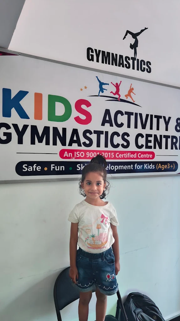 A girl standing below the Kids Activity & Gymnastics Centre sign