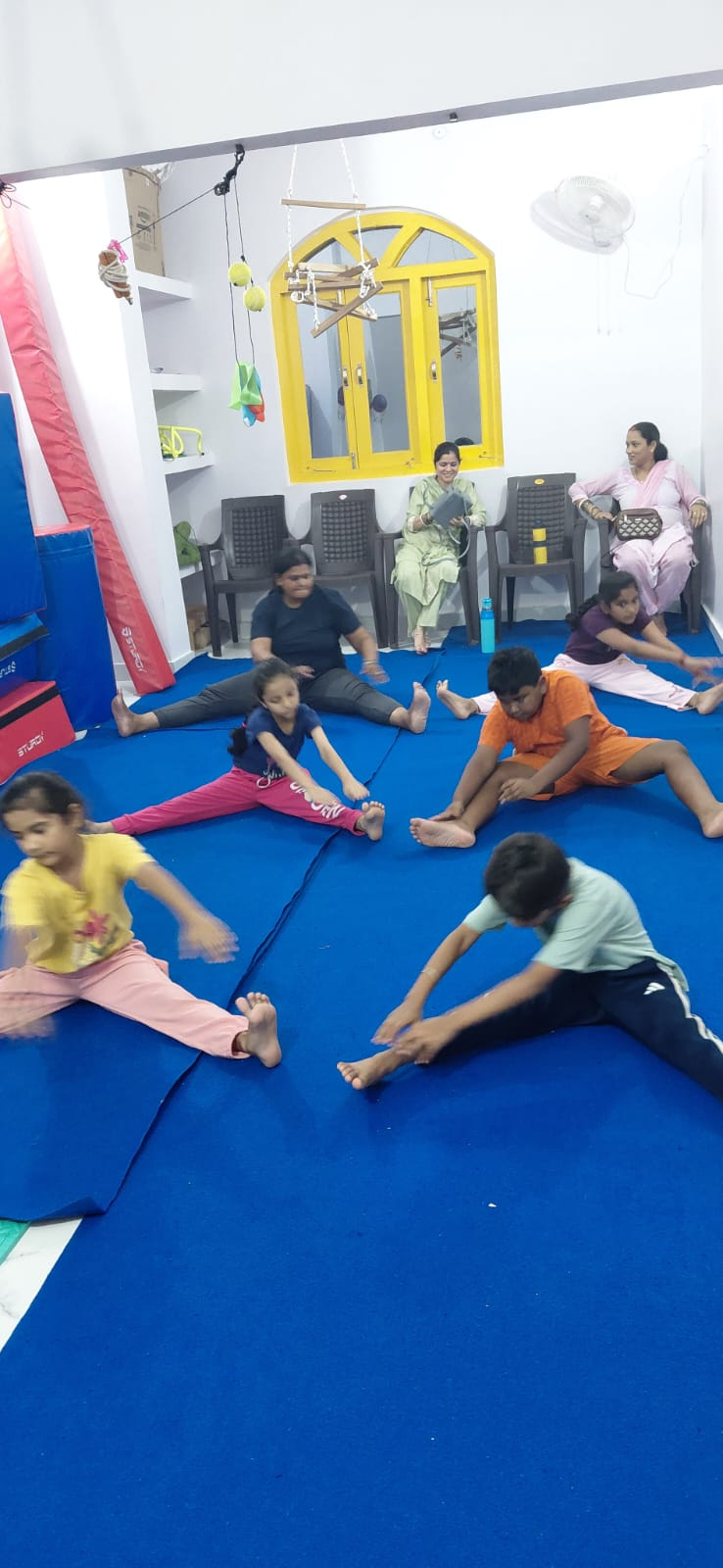 Children and adults stretching together during a group class